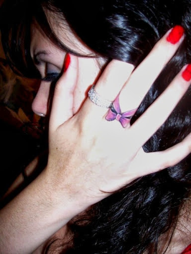 Nice Purple Ink Middle Finger Tattoo On Bow For Girl